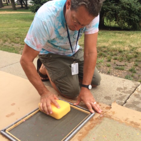 The deckle is flipped over and the excess water is gently pressed out using a sponge.